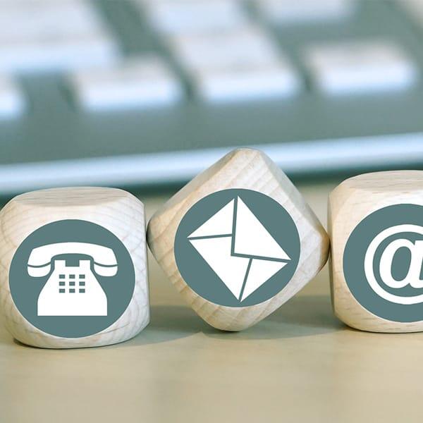 Pictogram met blokjes met daarop icoontjes van een telefoon, e-mail icoon en een apenstaartje